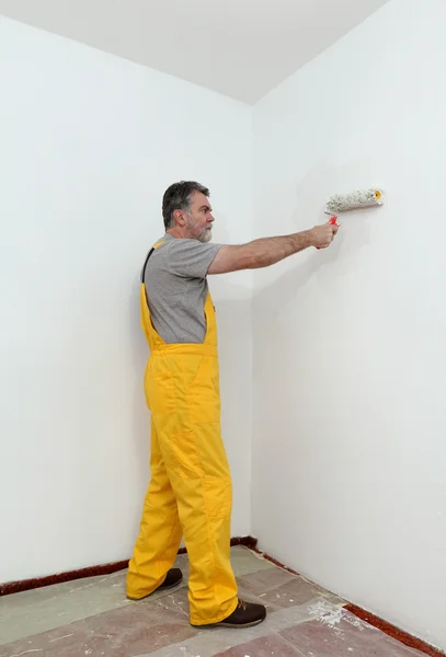 Pared de pintura de trabajador en habitación Imagen De Stock