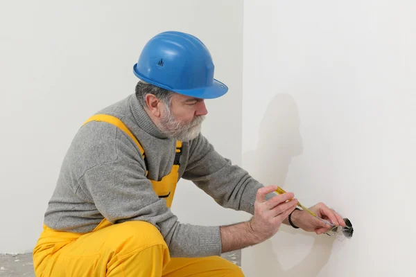 Elektriker auf Baustelle testet Installation lizenzfreie Stockfotos