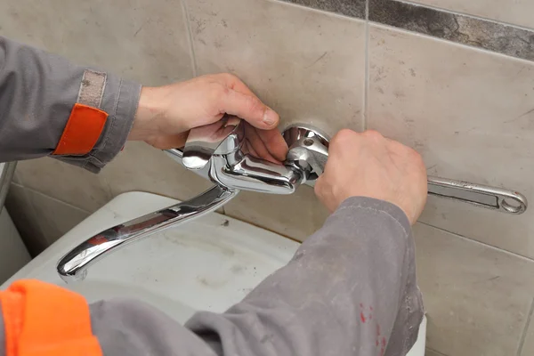 Robinet de fixation de plombier dans une salle de bain Image En Vente