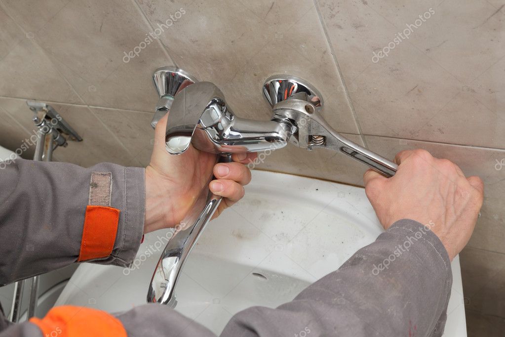 Plumber fixing faucet in a bathroom Stock Photo by ©simazoran 64918243