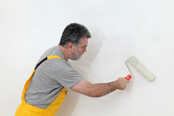 Werknemer schilderen muur in de kamer — Stockfoto