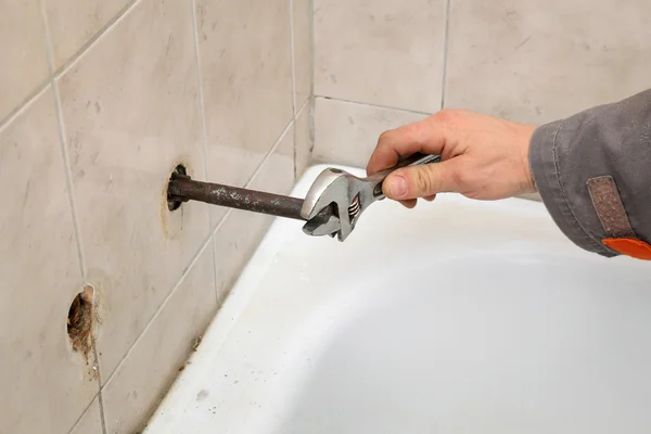 Loodgieter werkt in een badkamer — Stockfoto