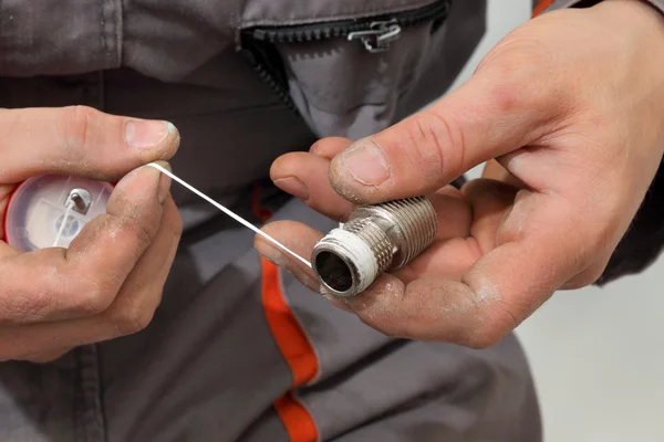 Plumber works in a bathroom — Stock Photo, Image