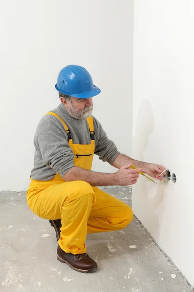 Elektriker auf Baustelle testet Installation lizenzfreie Stockfotos