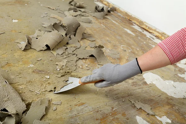 Worker using putty knife for cleaning floor — Stock Photo, Image