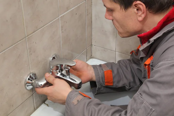Plumber works in a bathroom — Stock Photo, Image