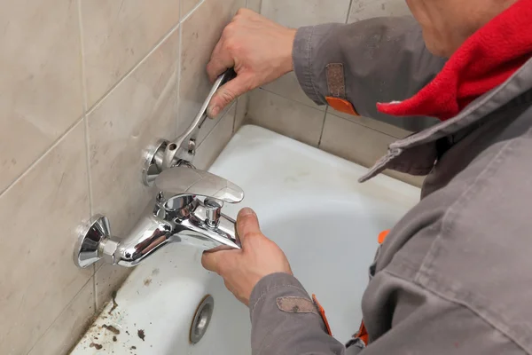 Plumber works in a bathroom Royalty Free Stock Images