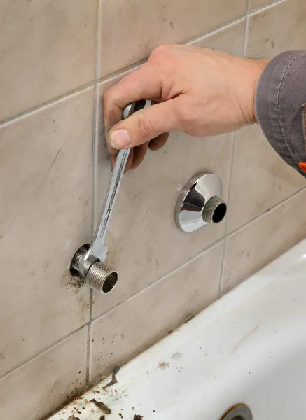 Plumber works in a bathroom Stock Picture