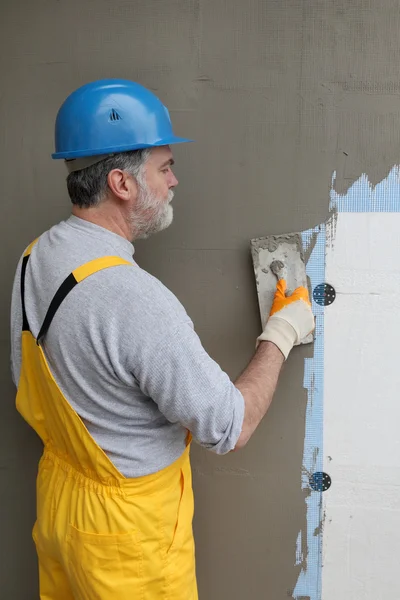 Wall insulation, spreading mortar over mesh and styrofoam — Stock Photo, Image