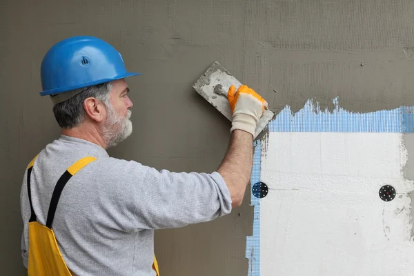 Wall insulation, spreading mortar over mesh and styrofoam — Stock Photo, Image