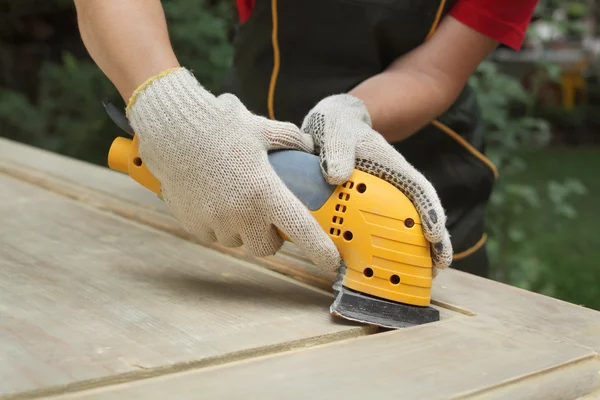 Home renovatie, werknemer schuren houten deur — Stockfoto