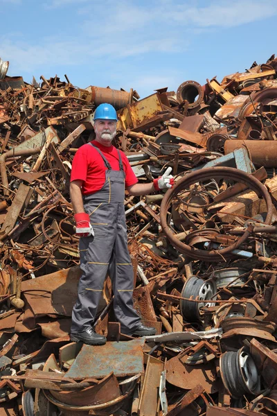 Recycling industrie, werknemer gebaar op hoop van oude metaal — Stockfoto