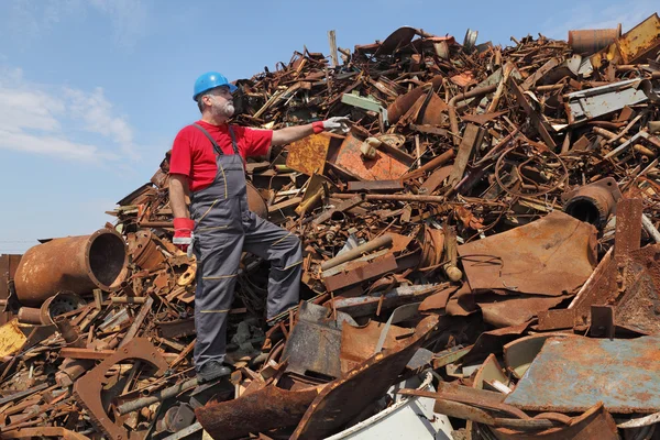 Recyklace průmyslu, pracovník gesto na hromadu starých kovů — Stock fotografie