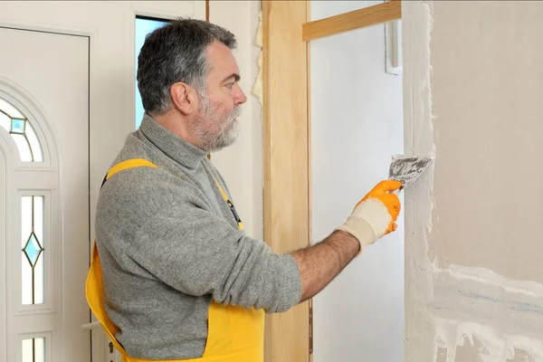 Construction site, worker installing gypsum board — Stock Photo, Image