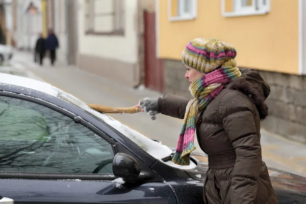 Samochodowych, kobieta usunąć śnieg z samochodu — Zdjęcie stockowe