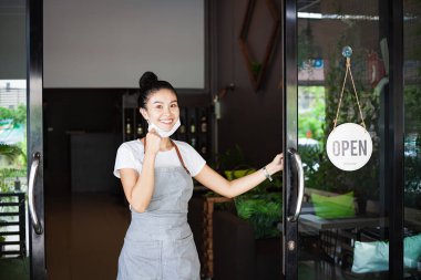 Mutlu Taylandlı garson, koruyucu maskeli, ayakta duran kapı aralığı, restoran yeniden açılıyor, Tayland, Koh Phangan 