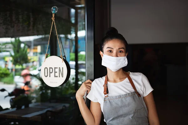 Mutlu Taylandlı garson, koruyucu maskeli, ayakta duran kapı aralığı, restoran yeniden açılıyor, Tayland, Koh Phangan 