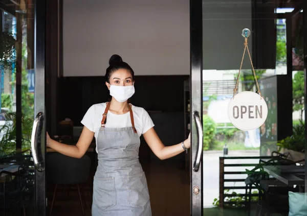Mutlu Taylandlı garson, koruyucu maskeli, ayakta duran kapı aralığı, restoran yeniden açılıyor, Tayland, Koh Phangan 