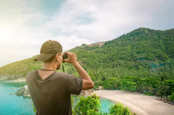Dürbünlü bir adam etrafındaki güzel doğayı inceler, Koh Phangan, Tayland