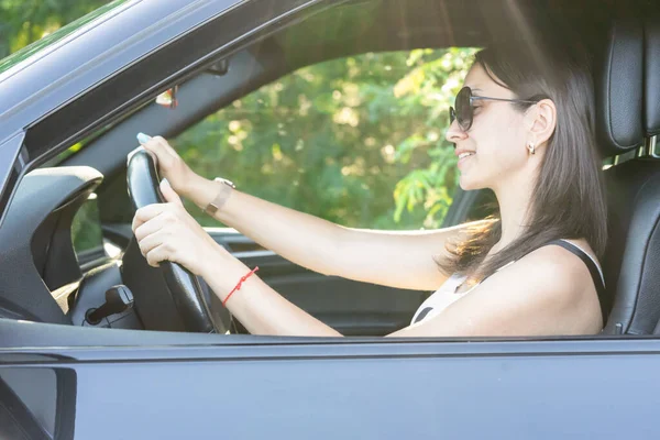 美しい女性は運転と笑顔 車の中で幸せな女の子の肖像画 旅行だ 人生を楽しむ — ストック写真