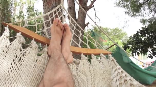 Feet of a person resting in a hammock — Stock Video