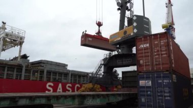 Yaz, 2020 - Vladivostok, Rusya - Deniz Konteynırı Terminali. Büyük bir liman vinci bir konteynırı bir ticaret gemisine yüklüyor.