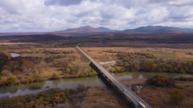 Yukarıdan bak. 4 bin. Kamera küçük bir nehrin üzerindeki bir yol köprüsünün üzerinden uçuyor. Sade manzara