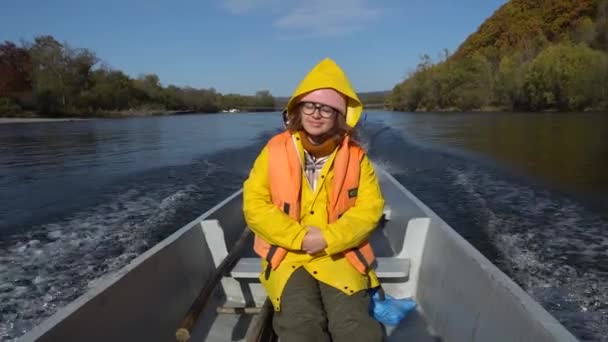 一个年轻的女孩沿着河边坐着一艘Udege船四处看看 一位游客正在河上坐船 — 图库视频影像