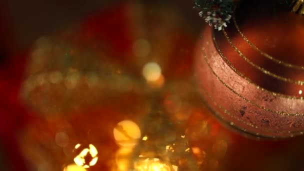 圣诞现场背景 宏观射击 摄像机从圣诞舞会上下来 落在装饰盒上 放着闪烁着强光的礼物 — 图库视频影像
