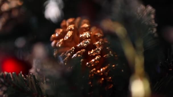 圣诞现场背景 新年的玩具 宏观射击 一种圣诞树玩具 形状是一个褐色的圆锥 边缘上闪烁着火花 挂在新年的树上 — 图库视频影像