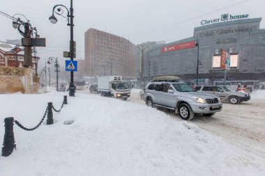 Ocak 2016 - Vladivostok, Rusya - Vladivostok 'ta yoğun kar yağışı. Vladivostok 'un merkez caddeleri boyunca arabalar kar yağışı sırasında sürüyorlar.