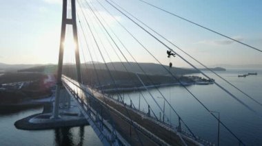 Yukarıdan bak. Kamera, Rus Köprüsü 'nün buzlu örtülerini ve Vladivsotok' taki dondurucu yağmurun sonuçlarından memnun olan endüstriyel dağcıyı aşıyor..