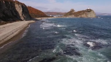 Yukarıdan bak. 4 bin. Kamera fırtınalı denizin üzerinde, vahşi bir plajın ve ulaşılamaz kayaların yanında döner..