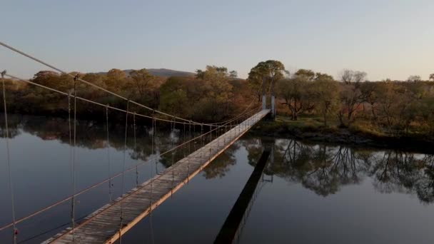 Eine Malerische Holzhängebrücke Über Den Fluss Vor Dem Hintergrund Herbstlicher — Stockvideo