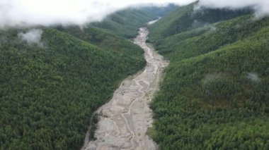Yukarıdan bak. 4 bin. Ekolojik felaket. Kamera, yemyeşil tepelerin arasındaki altın madencileri tarafından yok edilen bir derenin üzerinde uçuyor. Benimkini geliştirdi. Dağlardaki kirli nehir.