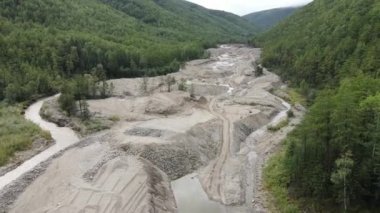 Yukarıdan bak. 4 bin. Ekolojik felaket. Kamera, yemyeşil tepelerin arasındaki altın madencileri tarafından yok edilen bir derenin üzerinde uçuyor. Benimkini geliştirdi. Dağlardaki kirli nehir.