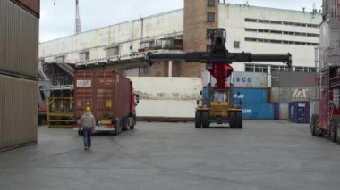 2020 yazında, Vladivostok, Rusya ticari deniz limanı Vladivostok 'ta çalışıyor. Büyük bir scacker bir konteyner deposunun önünden geçiyor..