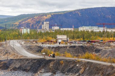 2016 sonbaharında - Magadan, Rusya - Ust-Srednekanskaya hidroelektrik santralinin inşaatı. Rusya 'nın kuzeyindeki sanayi binaları sonbahar dağlarının arka planına karşı.