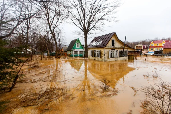 Ekolojik felaket. Kirli kahverengi bir nehrin deresi bir tatil köyünde zemin boyunca akar. Tatil köyü çamurlu bir akıntıya gömüldü.