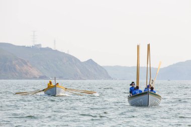 Vladivostok, Rusya - 2020, yaz - yatlarda kürek çeken bir deniz harp okulu öğrencisi tarafından denizcilik yarışması. Gençler tahta teknelerde Vladivostok 'un arka planına karşı yarışıyor.