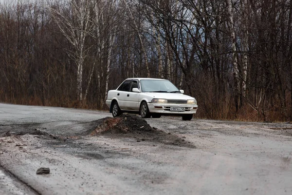 俄罗斯普里莫尔斯基 克雷伊 Primorsky Krai 2016年秋天 一辆汽车沿着一条死气沉沉的小路在高大的树林中行驶 俄罗斯公路 沥青质量差 — 图库照片