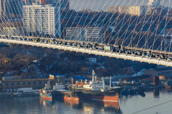 俄罗斯符拉迪沃斯托克 2016年冬季 汽车沿着符拉迪沃斯托克的金桥行驶 背景是海洋和城市 — 图库照片