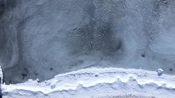雪の海岸 上からの眺め カメラは雪の海岸と海の上をホバリングし 海岸にスラッジが転がっている — ストック動画