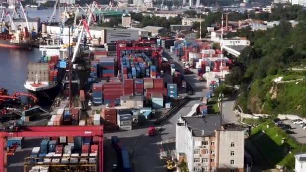 俄罗斯符拉迪沃斯托克 2020年夏天 符拉迪沃斯托克海运集装箱码头的运营 从上面看摄像机在一个露天集装箱仓库上空盘旋 身后是海参崴 — 图库视频影像
