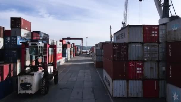 Die Kamera fliegt zwischen Containern am Be- und Entladehafen. — Stockvideo