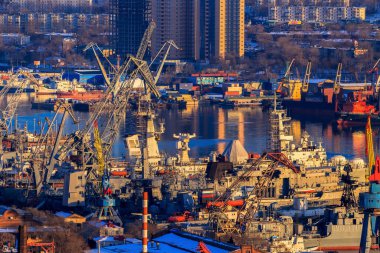 Vladivostok, Rusya, 2017 - Top view. Tüccar ve askeri gemiler Vladivostok 'ta bir tersanenin iskelesinde. Limandaki sakin suyun arka planında birçok gemi var.