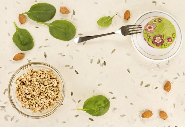 Roher veganer Spinatkuchen mit den rohen Marzipanblüten und -blättern Stockbild