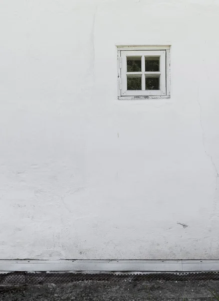 A velha parede rebocada branca com uma pequena janela e uma palmadinha de pedra Imagens De Bancos De Imagens