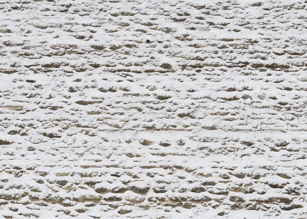 Old wall from limestone powdered with snow in the winter — Stock Photo, Image