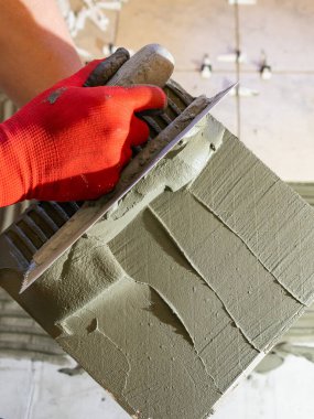 İnce bir havan topunu fayansa sürüyorum. Yapıştırıcıyı uygula, yakın çekim.